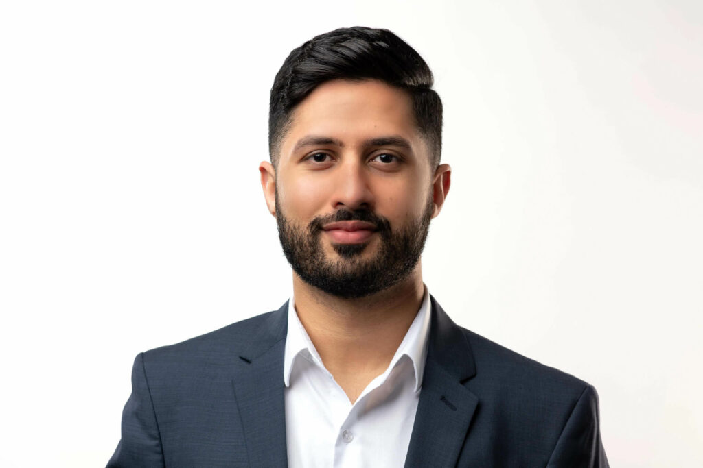 Headshot of a man with a nicely trimmed beard on a white background